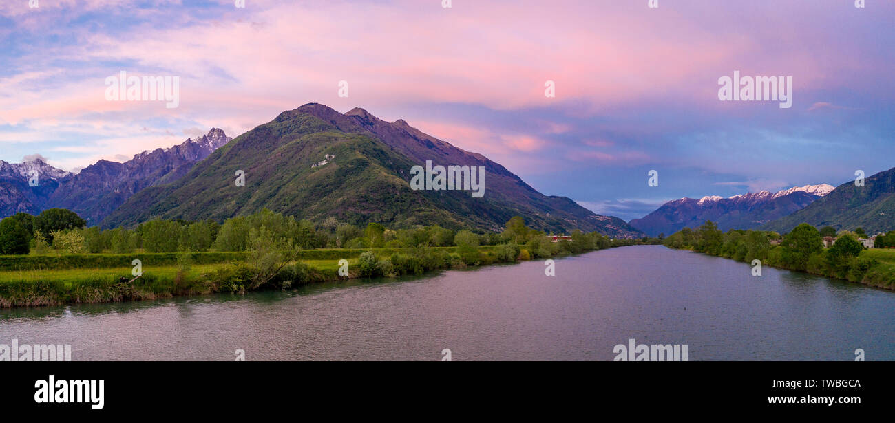 Vue panoramique aérienne de coucher de soleil sur le fleuve Adda et Alpes Rhétiques, province de Sondrio, Valtellina, Lombardie, Italie Banque D'Images