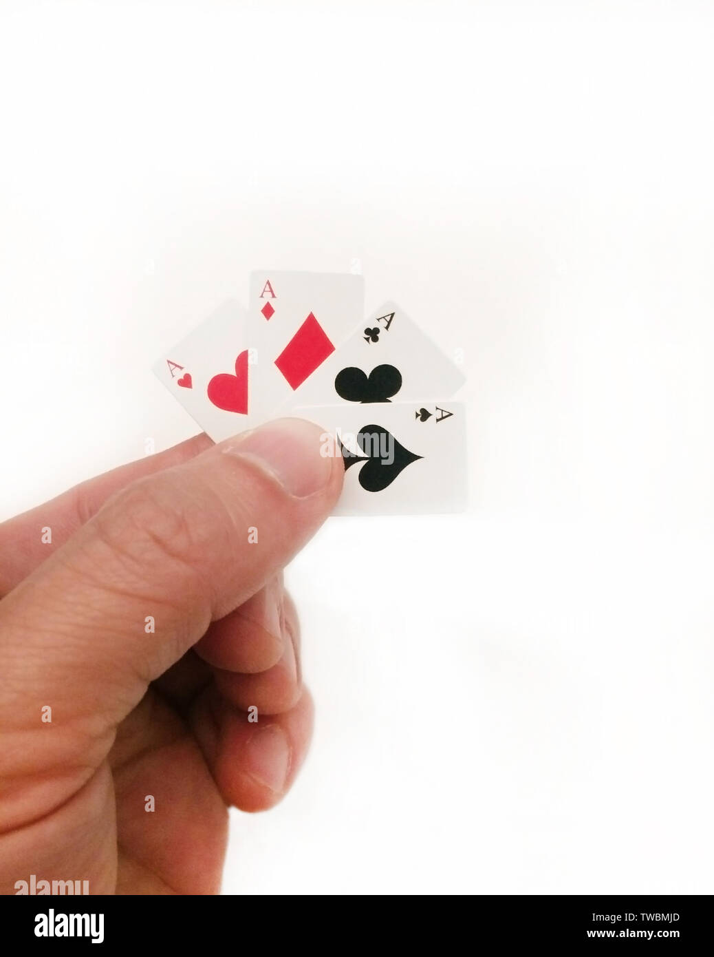 Hand holding tiny cartes : Quatre As Banque D'Images