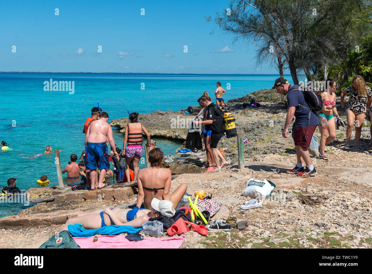 Les touristes d'entrer dans la mer pour faire de la plongée avec tuba et la plongée en face de la grotte de poissons (Cueva de los Peses) Playa Larga, Cuba Banque D'Images