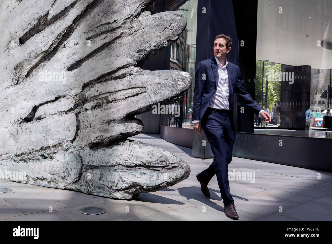 Un homme passe devant la sculpture intitulée 'ville' aile sur Threadneedle Street dans la ville de Londres, le quartier financier de la capitale, le 17 juin 2019, à Londres, en Angleterre. Cette dix mètres de haut est la sculpture en bronze par le président de la Royal Academy of Arts, Christopher Le Brun, commandé par Hammerson en 2009. 'La Ville' de l'aile et a été jeté par Morris Singer, fondateurs de l'art réputé pour être la plus ancienne fonderie d'art dans le monde. Banque D'Images