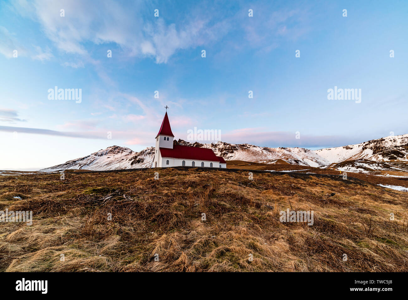 Petite église située au sommet d'une colline, offrant une vue pittoresque sur l'océan et le village de Vik. Banque D'Images