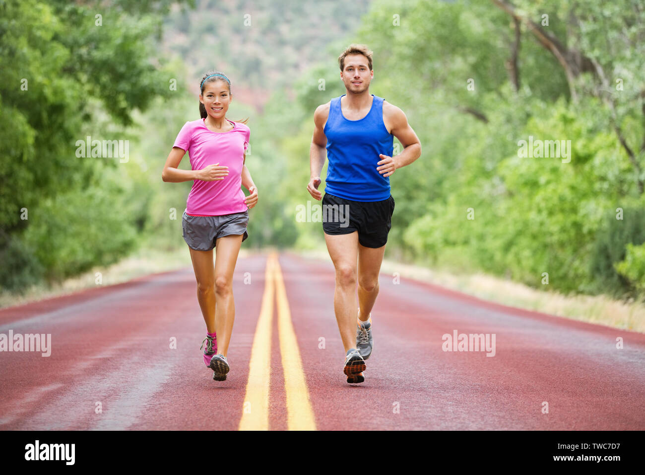 Fitness sport couple running jogging à l'extérieur sur la belle nature paysage. Porteur de la formation de marathon. Femme Asiatique femme Sport et fitness homme mâle en pleine longueur du corps. Banque D'Images