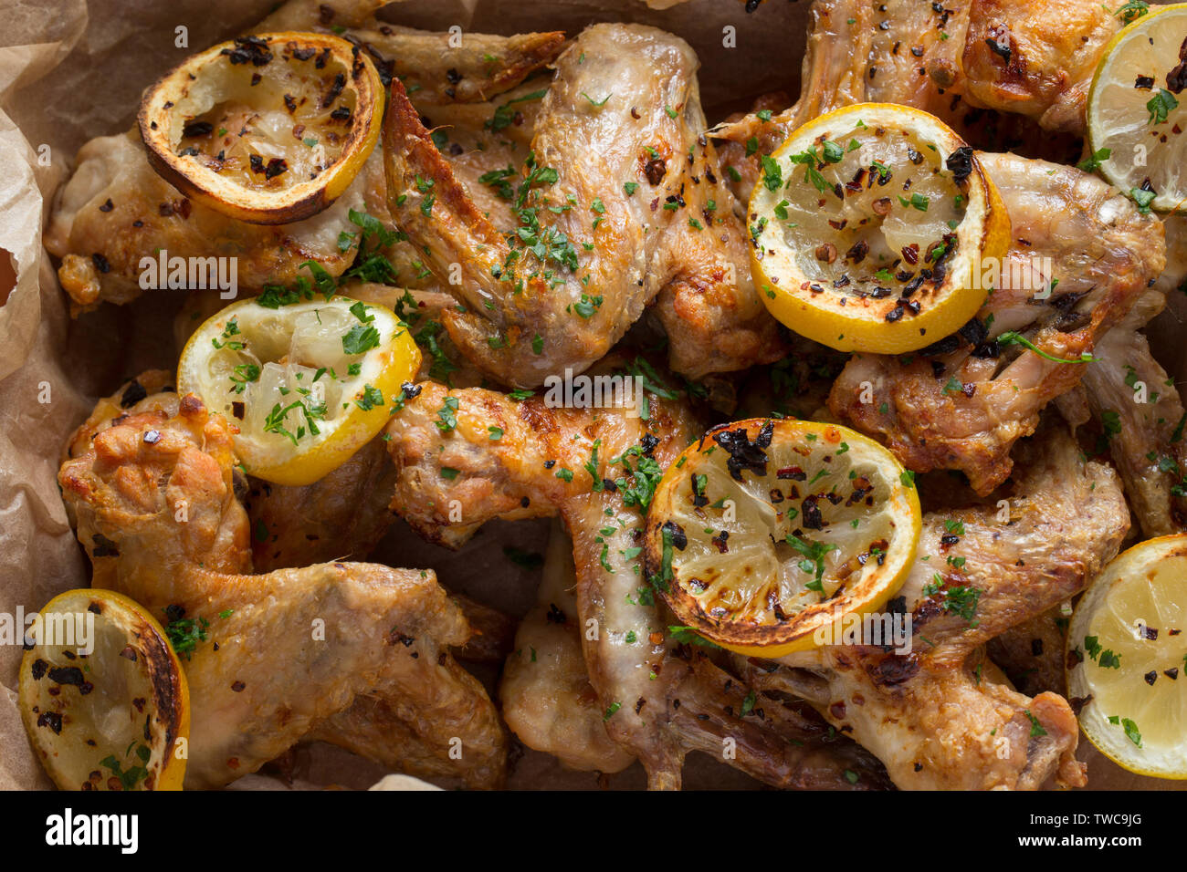 Ailes de poulet cuites britanniques ont acheté dans un supermarché au Royaume-Uni qui ont été grillée avec des flocons de piment et de tranches de citron et de lime. En Dorset Banque D'Images