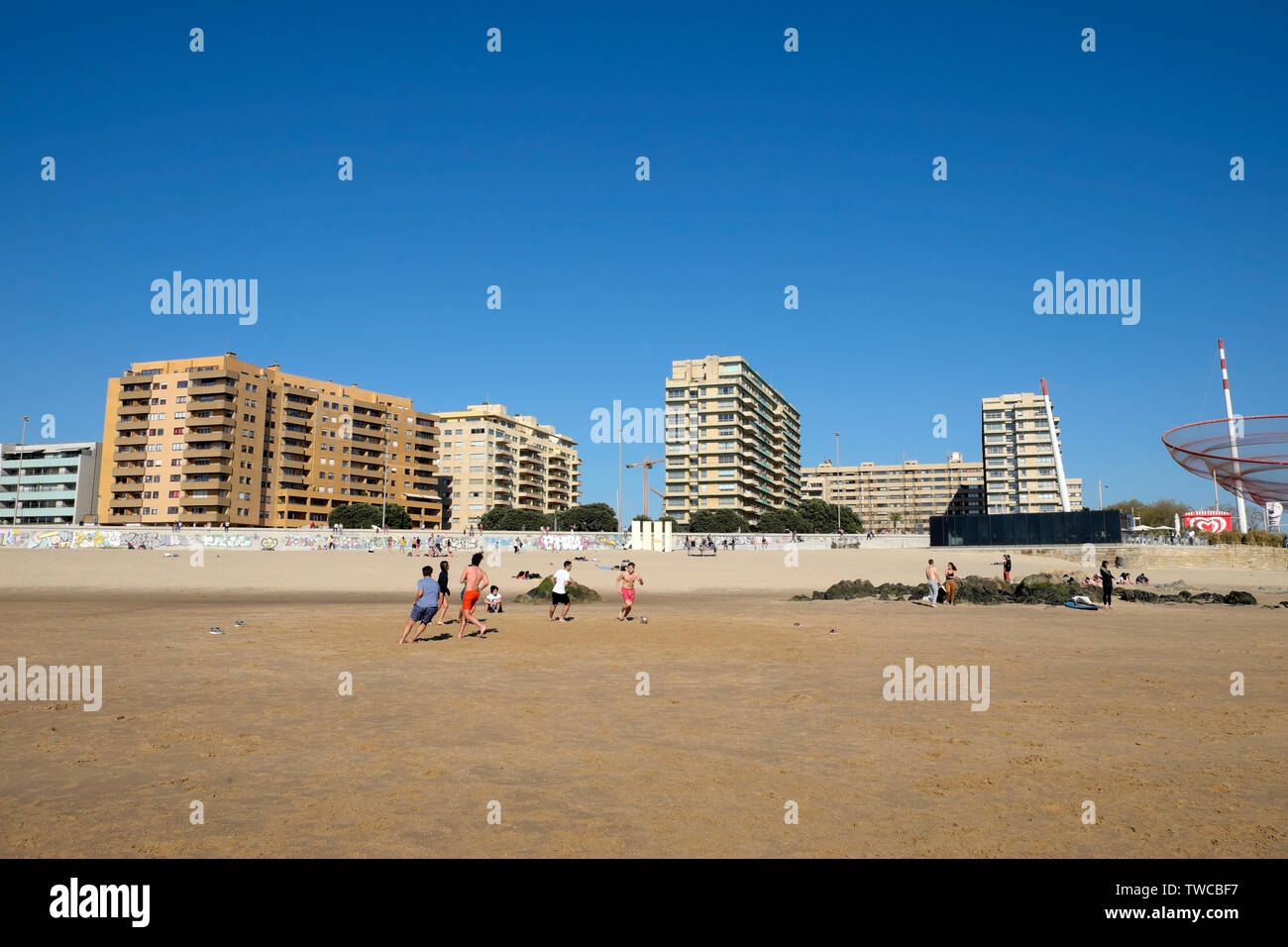Appartement moderne, les bâtiments et les jeunes jouent au football sur la plage de soleil du printemps à Matosinhos Porto Portugal Europe UE KATHY DEWITT Banque D'Images