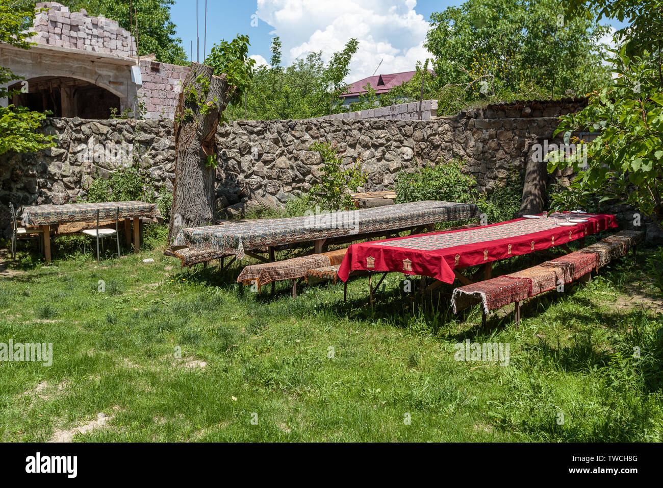 De grandes tables et des bancs dans un jardin couvert de tissus colorés Banque D'Images