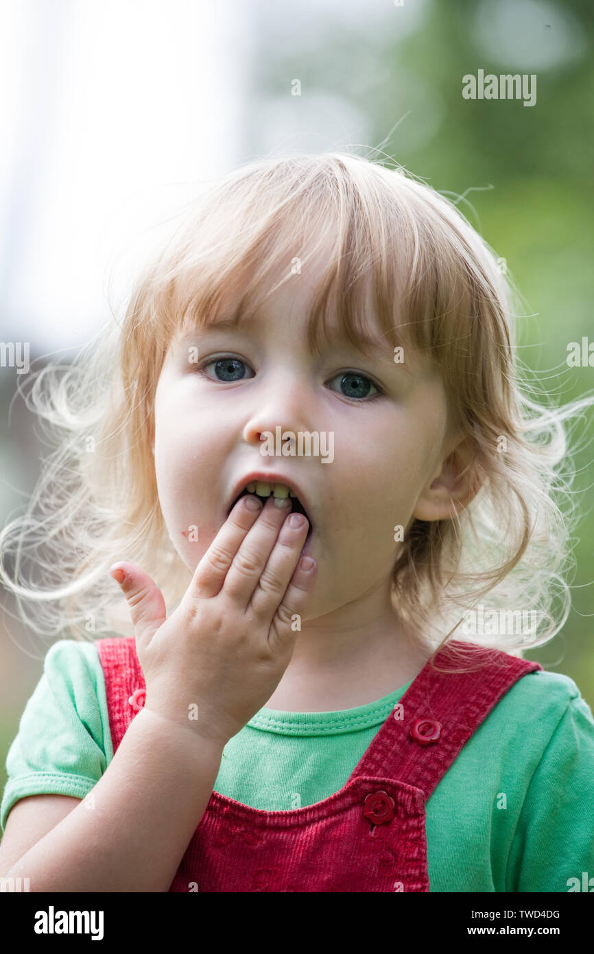 Petit enfant avec la bouche ouverte closeup portrait sur fond de plein air d'été Banque D'Images