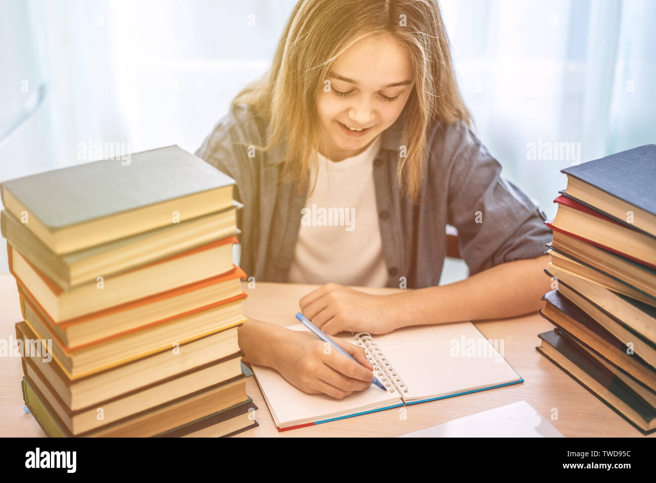 Young student sitting at desk in home l'étude et la lecture, faire des devoirs et préparation à l'examen pratique de la leçon, de l'éducation entrée concept. Banque D'Images