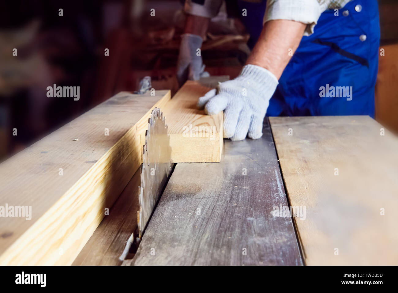 Carpenter travaille sur machines à bois dans l'atelier de menuiserie. Un homme travaille avec un arbre Banque D'Images
