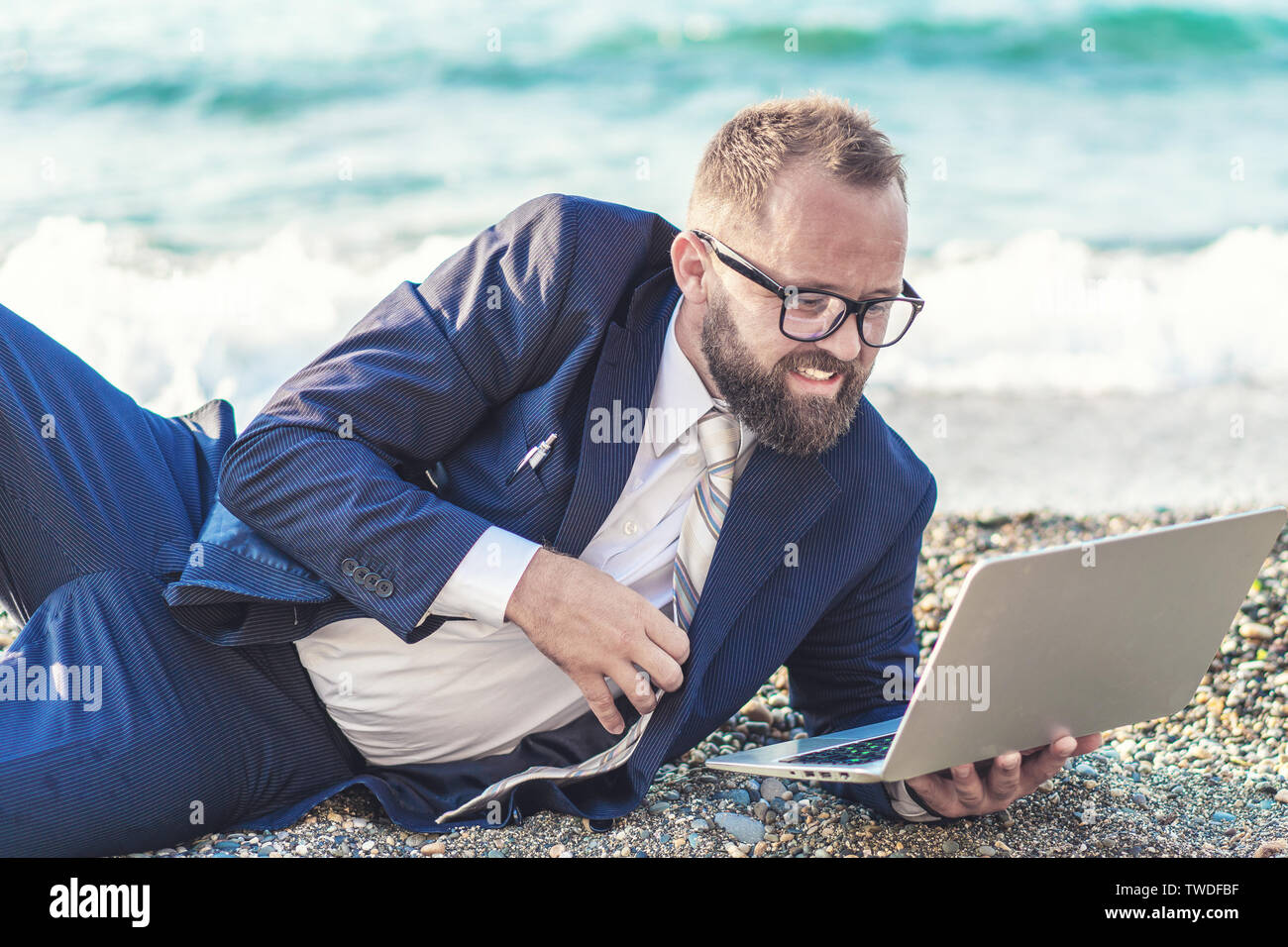 Man travaille sur son ordinateur portable sur la plage. Close up Banque D'Images