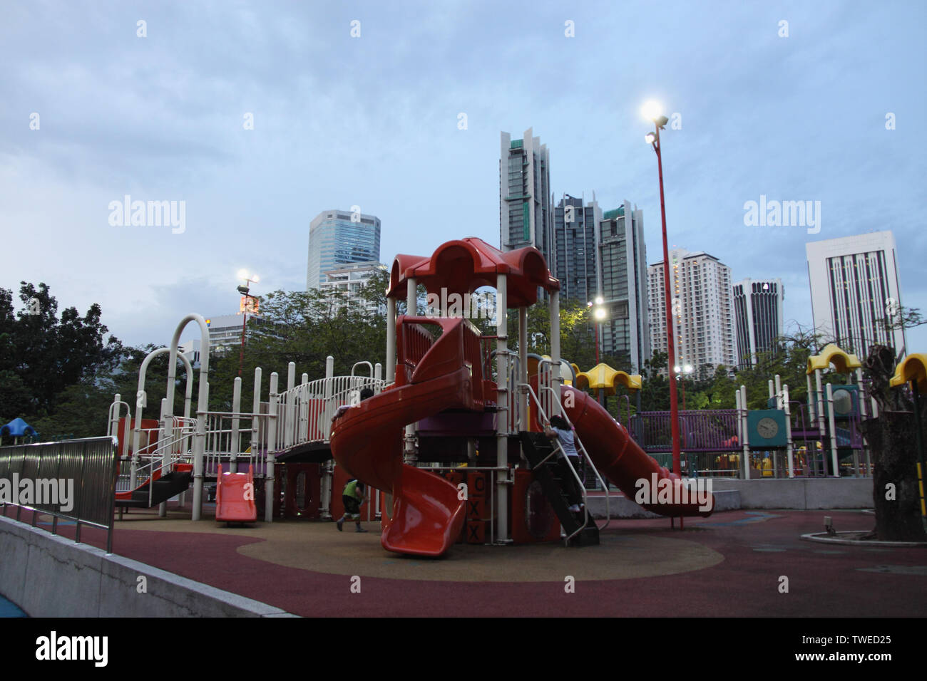 Glissez dans un terrain de jeu avec vue sur la ville en arrière-plan, Kuala Lumpur, Malaisie Banque D'Images