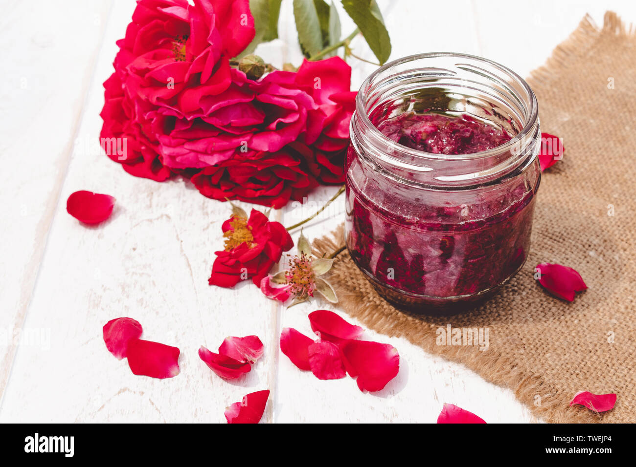 Confiture de pétales de rose dans un bocal de verre sur un fond clair. Confiture de fleurs. Alimentation saine. Copy space Banque D'Images