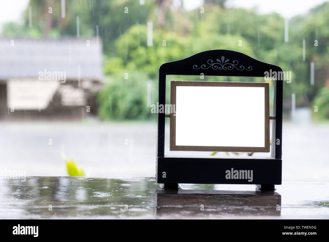 Cadre photo vide vintage design avec rainy sur table en bois Banque D'Images