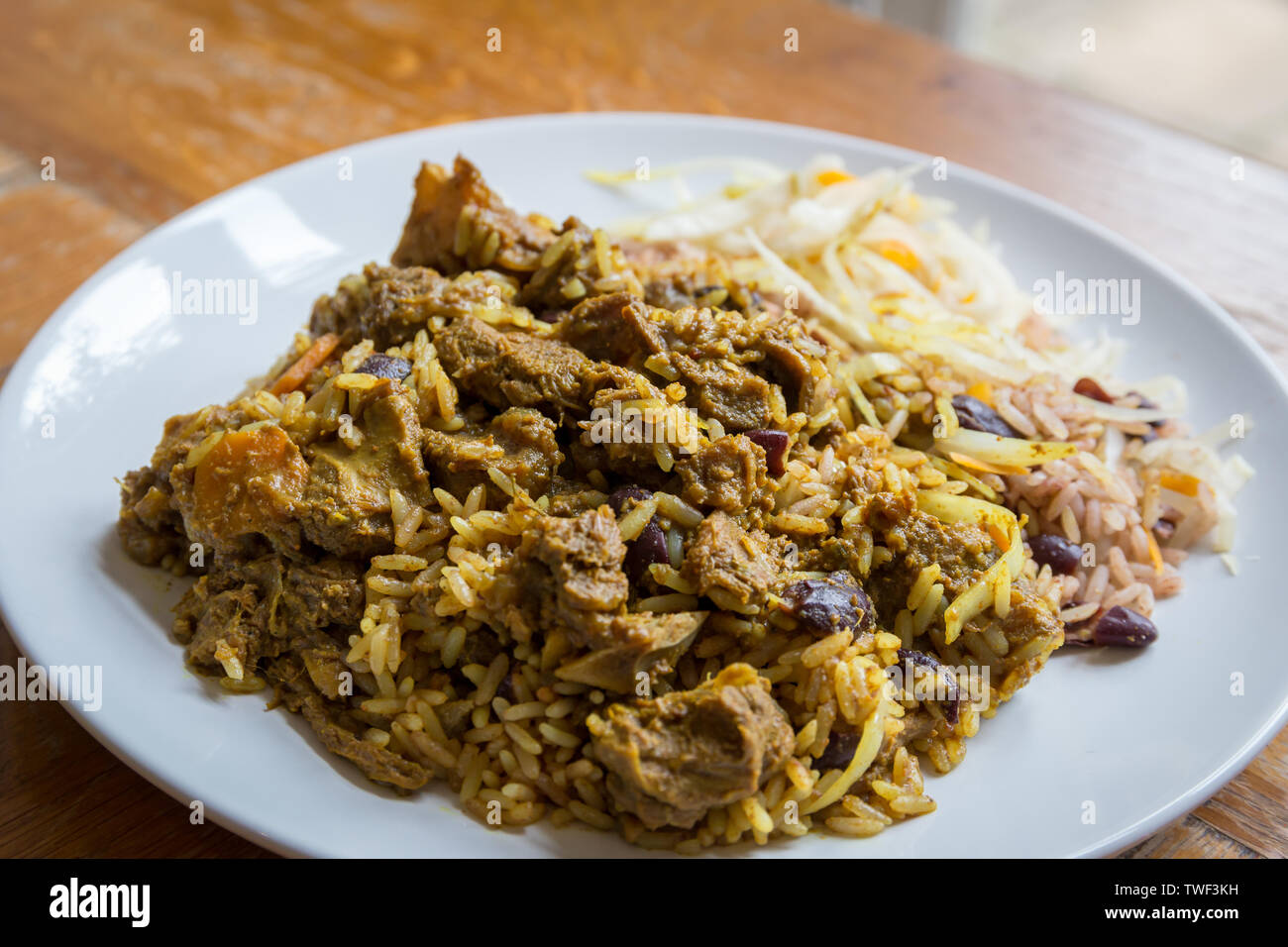 Nourriture jamaïcaine. Chèvre au curry jamaïcain servi avec riz et pois traditionnels Banque D'Images