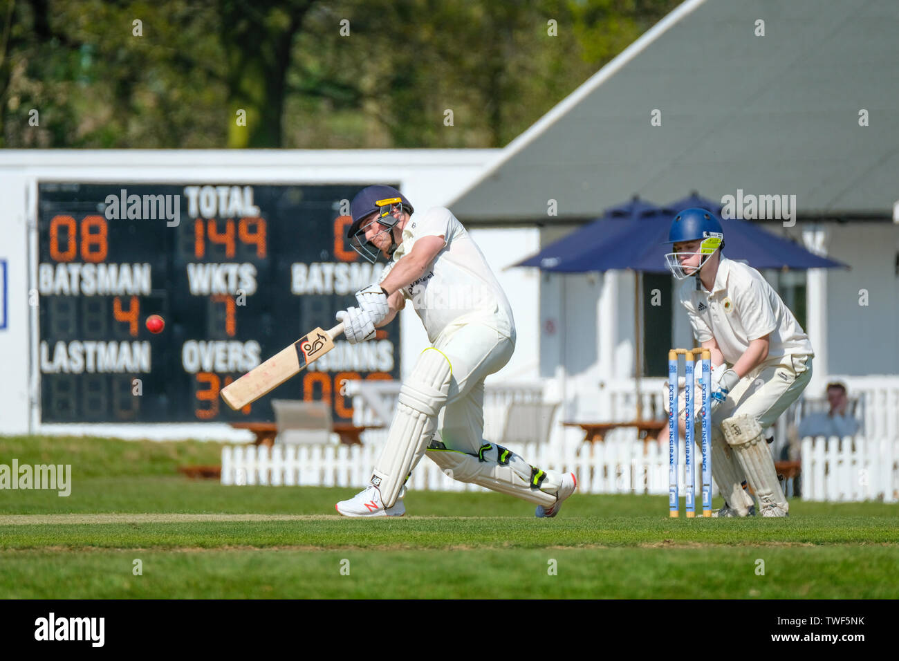 La lecture d'un batteur tourné vers la mi sur à un match de cricket dans le Leicestershire Rothley. Banque D'Images