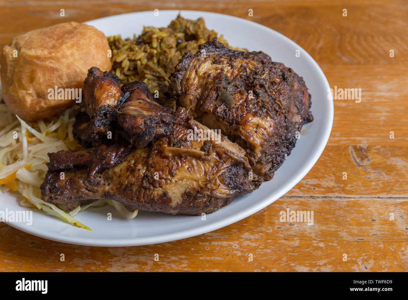 Nourriture jamaïcaine. Chèvre au curry jamaïcain traditionnel, poulet jerk et fried dumpling avec du riz et des pois. Banque D'Images