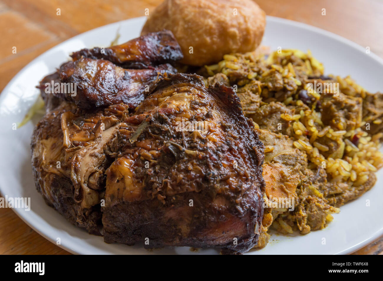 Nourriture jamaïcaine. Chèvre au curry jamaïcain traditionnel, poulet jerk et fried dumpling avec du riz et des pois. Banque D'Images