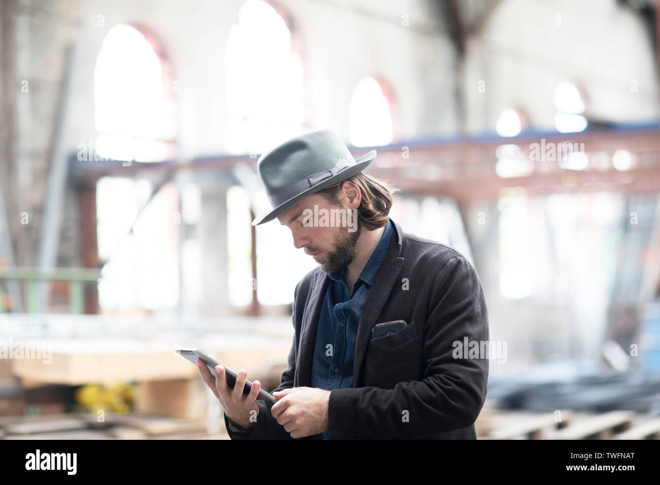 Portrait d'un homme debout, dans un bâtiment en cours de rénovation à la tablette numérique à un Banque D'Images