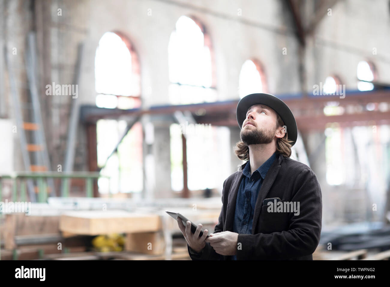 Portrait d'un homme debout, dans un bâtiment en cours de rénovation à la tablette numérique à un Banque D'Images