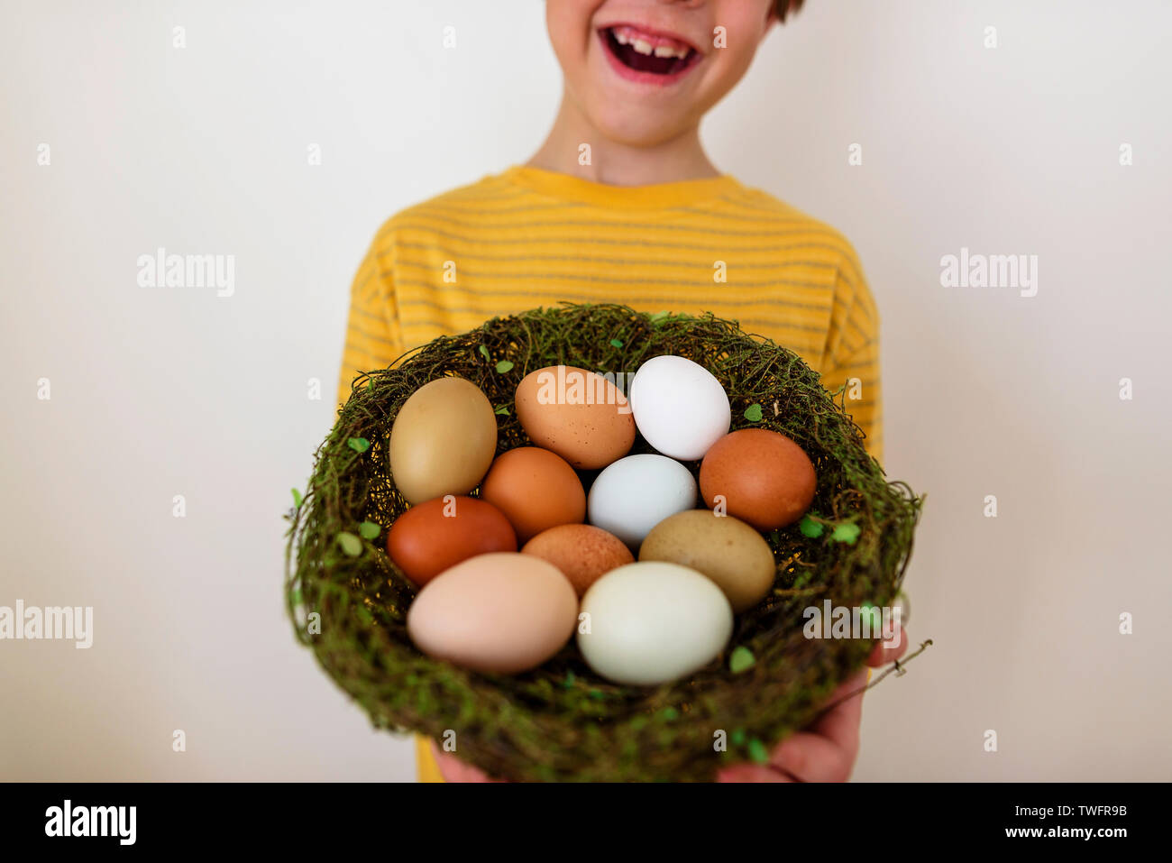Portrait of a happy boy holding un nid avec des oeufs frais Banque D'Images
