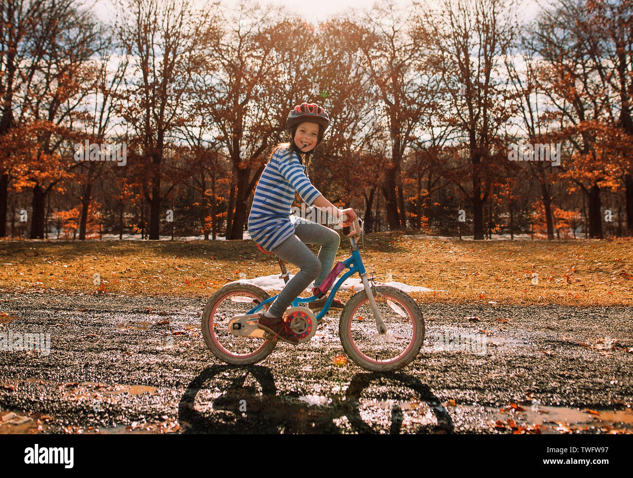Smiling girl de rouler à vélo dans le parc, United States Banque D'Images