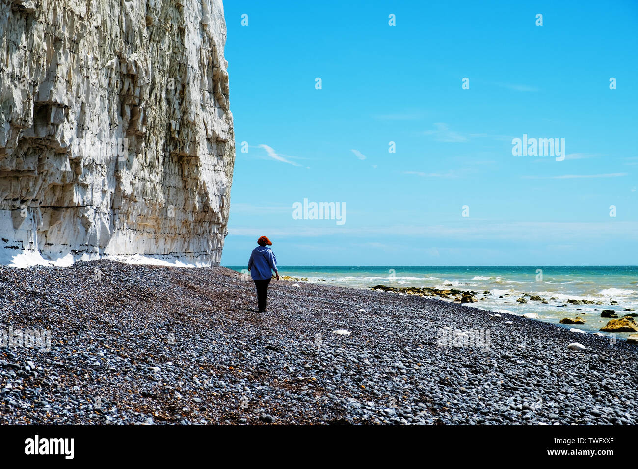 Femme marche sur la plage vers les falaises de Pentecôte Banque D'Images