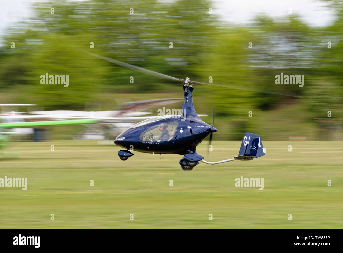 Rotorsport sport bleu Cavalon Autogyre avion décolle à l'aérodrome de Popham près de Basingstoke, Hampshire, Royaume-Uni Banque D'Images