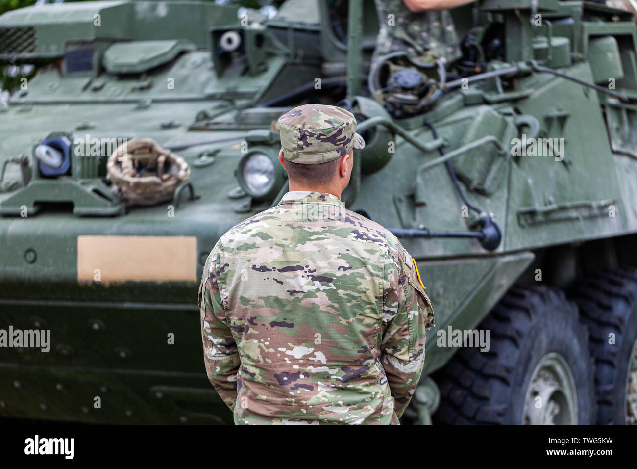 Un soldat de l'armée des États-Unis se place en avant d'un véhicule de combat blindé Banque D'Images