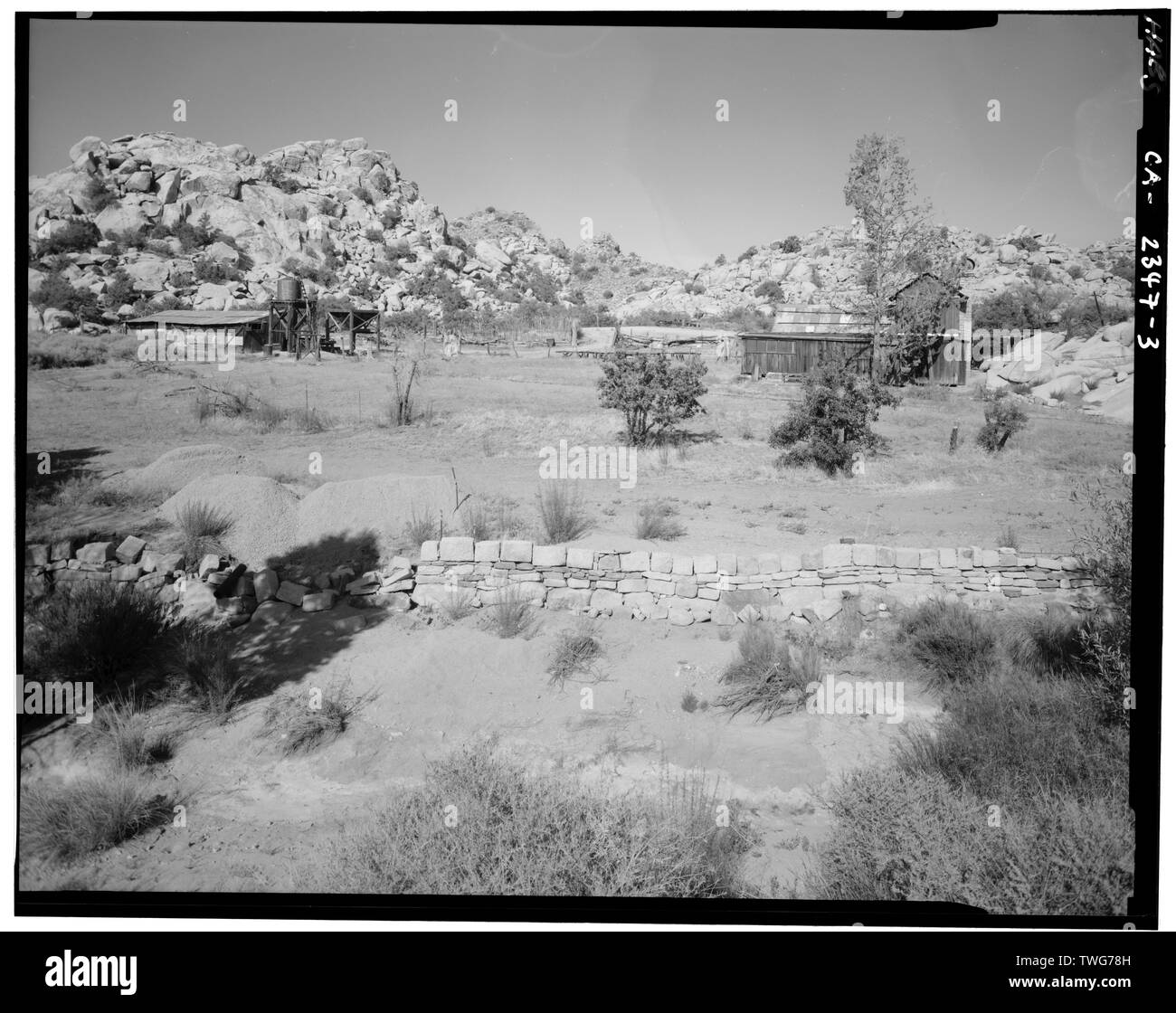 Motifs à SW RANCH À L'ARRIÈRE DU RANCH HOUSE. Mur de soutènement DU CANAL EN PREMIER PLAN. Boutique MACHINE À DISTANCE À GAUCHE. - Reine du désert Ranch, Twentynine Palms, Comté de San Bernardino, CA Banque D'Images