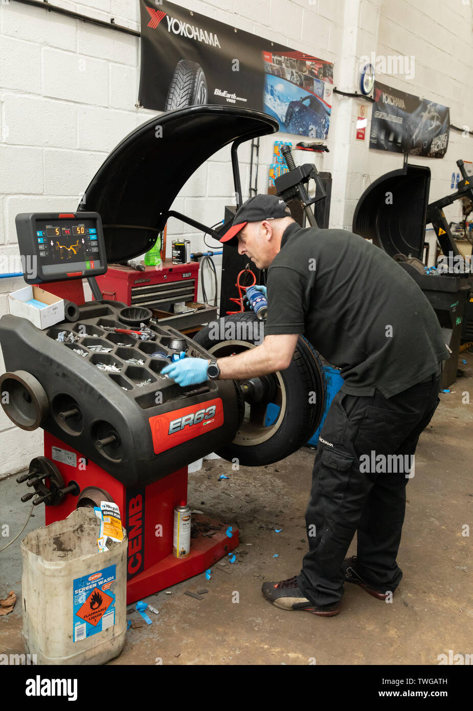 L'équilibrage des roues de voiture mécanicien après nouveau pneu a été installé. Bury Centre du pneu à Bury St Edmunds, Suffolk, UK Banque D'Images