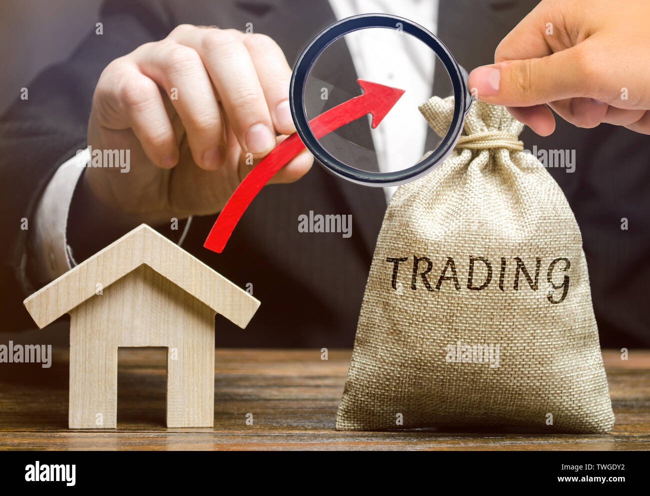 Un sac d'argent avec le mot Trading, une flèche et une maison en bois. Le concept de l'augmentation de la demande d'achat de maison. La croissance de l'offre. Des liquidi Banque D'Images