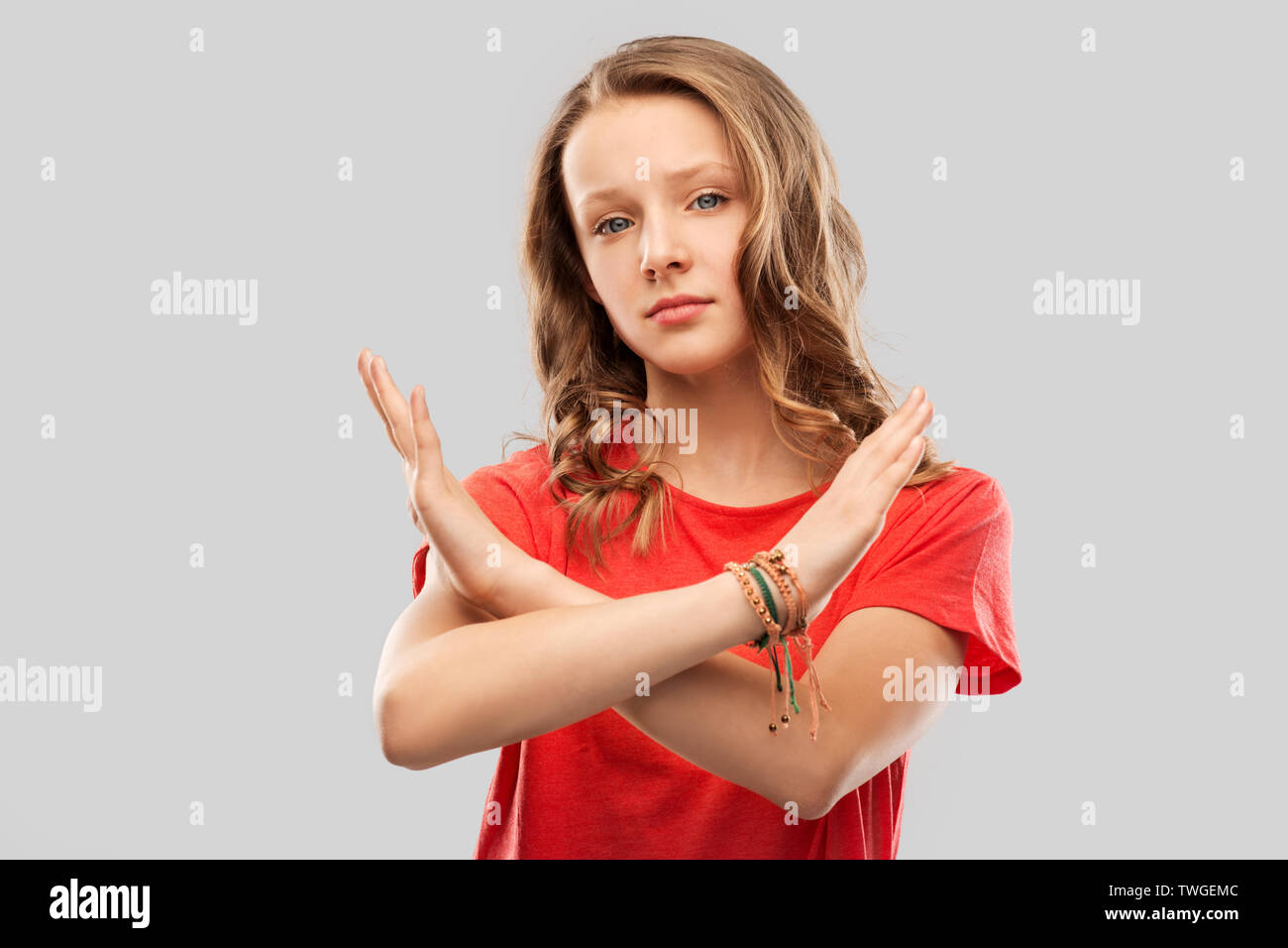Teenage girl crossing mains en geste interdit Banque D'Images
