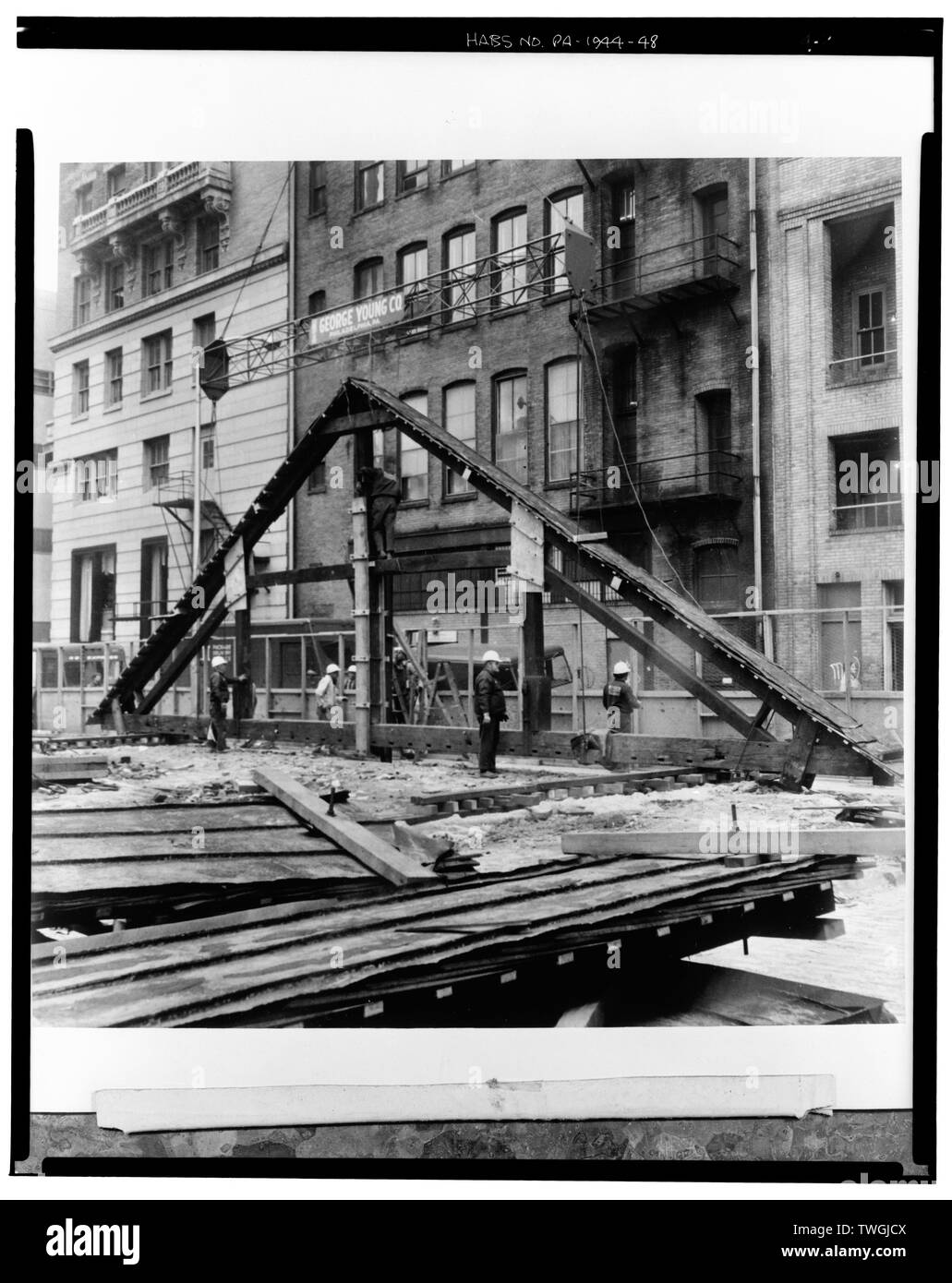 Dépose de la première poutrelle. La première truss supprimées ici repose sur les plaques au sol et attend le même placement de toutes les fermes pour le stockage temporaire. Au premier plan sont couper des sections de la toiture également supprimé par grue. Remarque Le 1873-74 joints debout au-dessus du toit en tôle chasse de 1851. Le pôle de toit gouttières ont été en partie composé de rails arrière banc. - Douzième Réunion, 20 rue Maison Du Sud 12e Street, Philadelphia, comté de Philadelphie, PA Banque D'Images