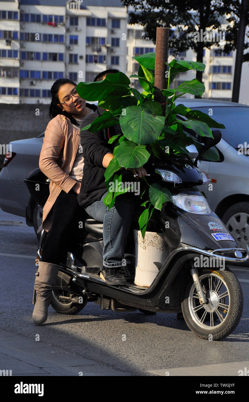 Couple chinois d'une usine de transport sur un scooter dans l'impossibilité de voir l'avant Banque D'Images