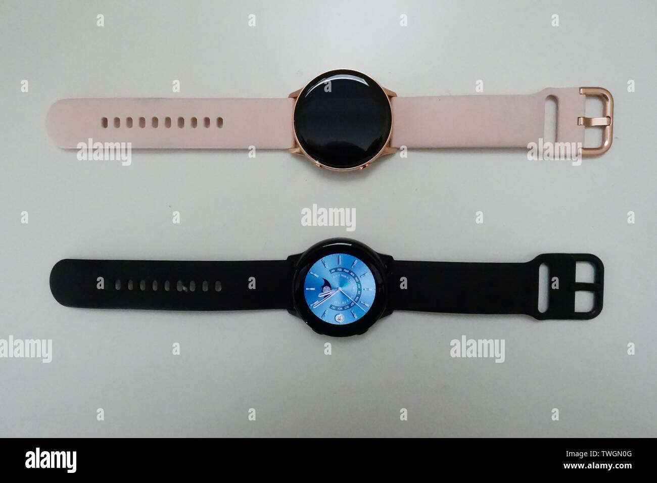 Un noir et l'or rose Samsung Galaxy S3 Active Smart Watches fixant les uns à côté des autres sur un fond blanc. Banque D'Images