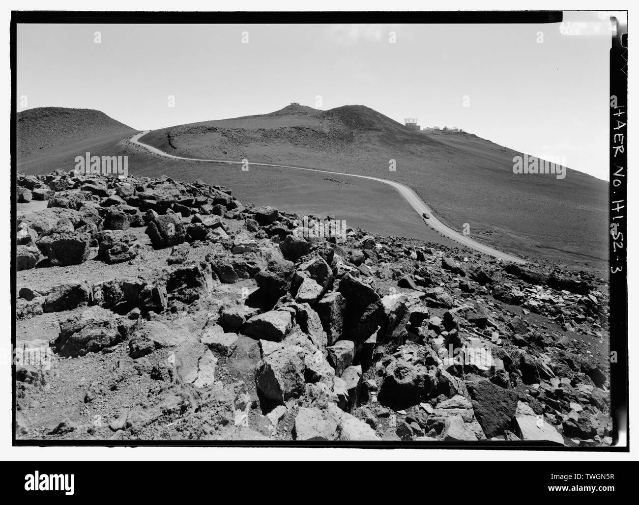 Route DE SOMMET MONDIAL MONTRANT SYNDICAT DONNENT SUR LA SCIENCE ET LA VILLE, DU HAUT DE LA COLLINE BLANCHE. Remarque Les VESTIGES DE CE QUI SEMBLE ÊTRE UN ABRI CIRCULAIRE EN BAS À DROITE. - Les routes du parc national de Haleakala, Pukalani, comté de Maui, HI Banque D'Images