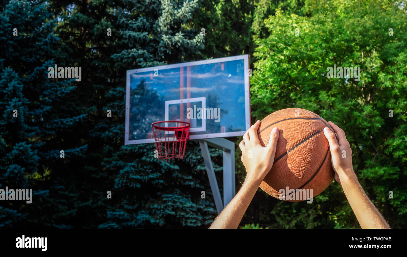 Les mains d'un adolescent avec une basket-ball sur la tête avant de jeter  dans le panier au cours d'un match de basket-ball de rue Photo Stock - Alamy