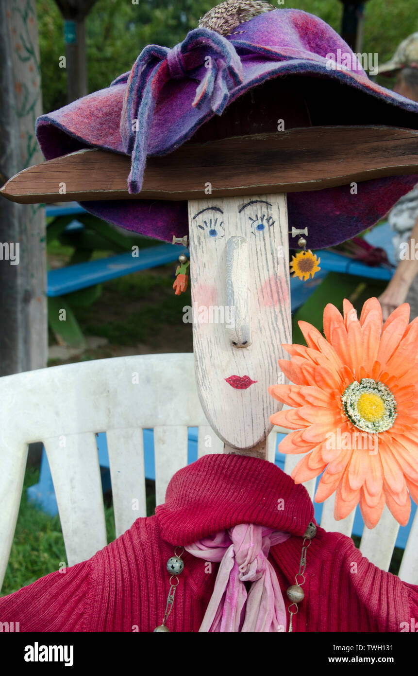 Gros plan de Wilma l'épouvantail femelle avec un visage peint et un chapeau violet supervisant le jardin communautaire, Maine, USA Banque D'Images