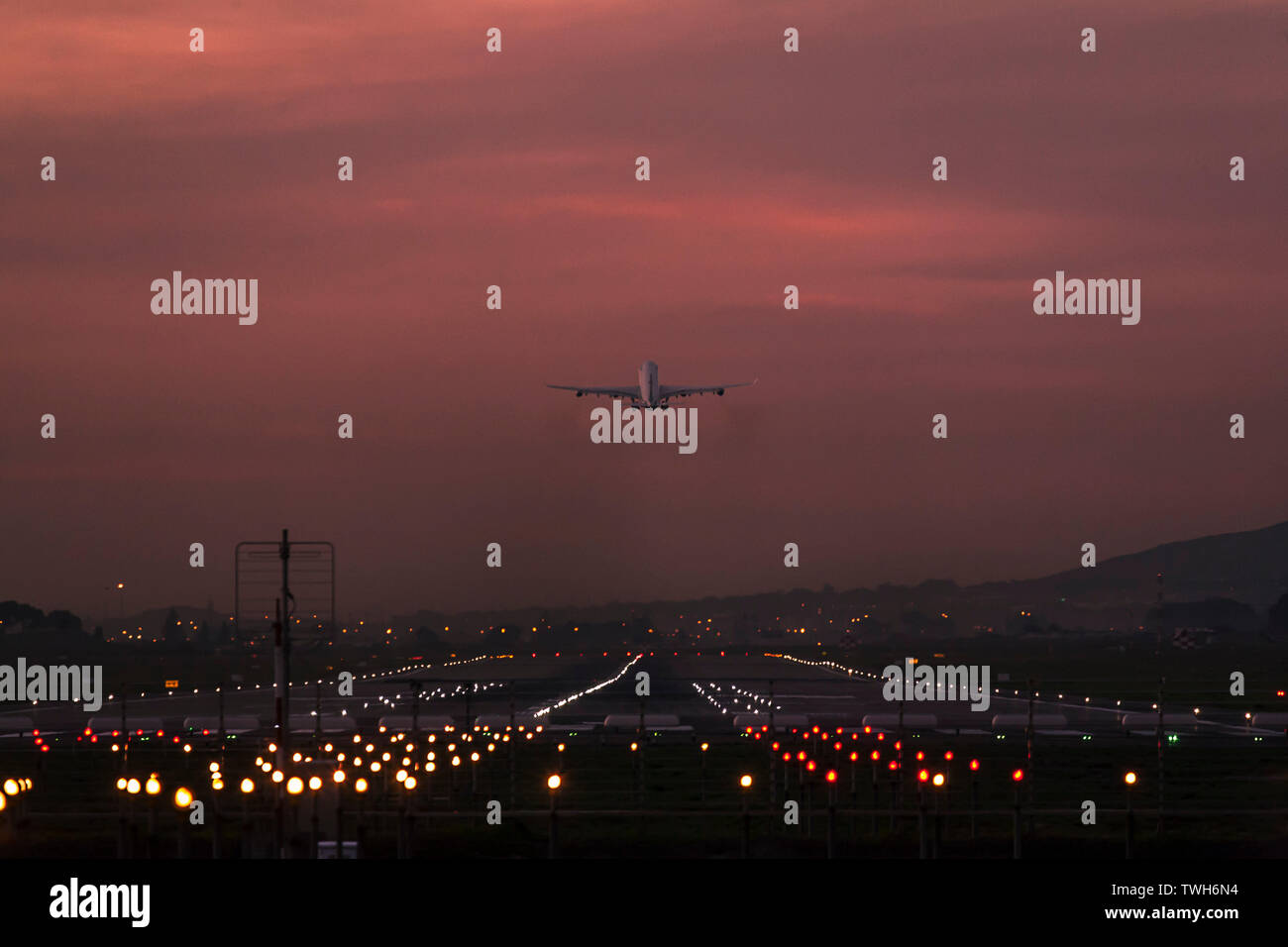 Avion de passagers au départ de l'Aéroport International de Cape Town au crépuscule avec la piste d'atterrissage de toute évidence s'illuminèrent. Banque D'Images