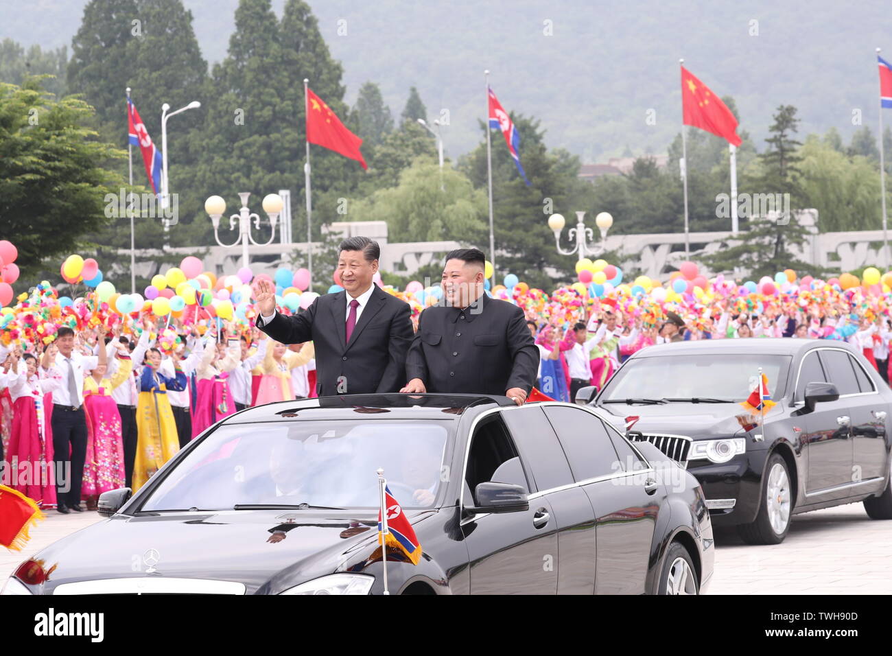 Pyongyang, RPDC. 20 juin 2019. Secrétaire Général du Comité central du Parti communiste chinois (PCC) et le président chinois Xi Jinping et Kim Jong Un, président du Parti du Travail de Corée (PTC) et président de la Commission des affaires de l'état de la République populaire démocratique de Corée (RPDC), trajet d'un véhicule pour le carré de la palais Kumsusan du Soleil au milieu de foules accueillant, à la suite d'une grande cérémonie d'accueil tenue par la RPDC à l'Aéroport International de Sunan, à Pyongyang, RPDC, le 20 juin 2019. Source : Xinhua/Alamy Live News Banque D'Images