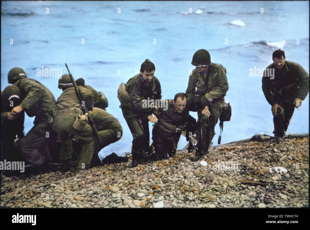 Les soldats américains du 116e régiment de la 29e Division d'infanterie, de l'aide à la côte après son arrivée à Omaha Beach en radeau après leur débarquement, Véhicule personnel (LCVP) avait été coulé au large de pont, Nicholas Hermance (3e à partir de la droite), il a été traîné sur terre par deux soldats, l'opération Overlord, bataille de Normandie, France, le 7 juin 1944 Banque D'Images