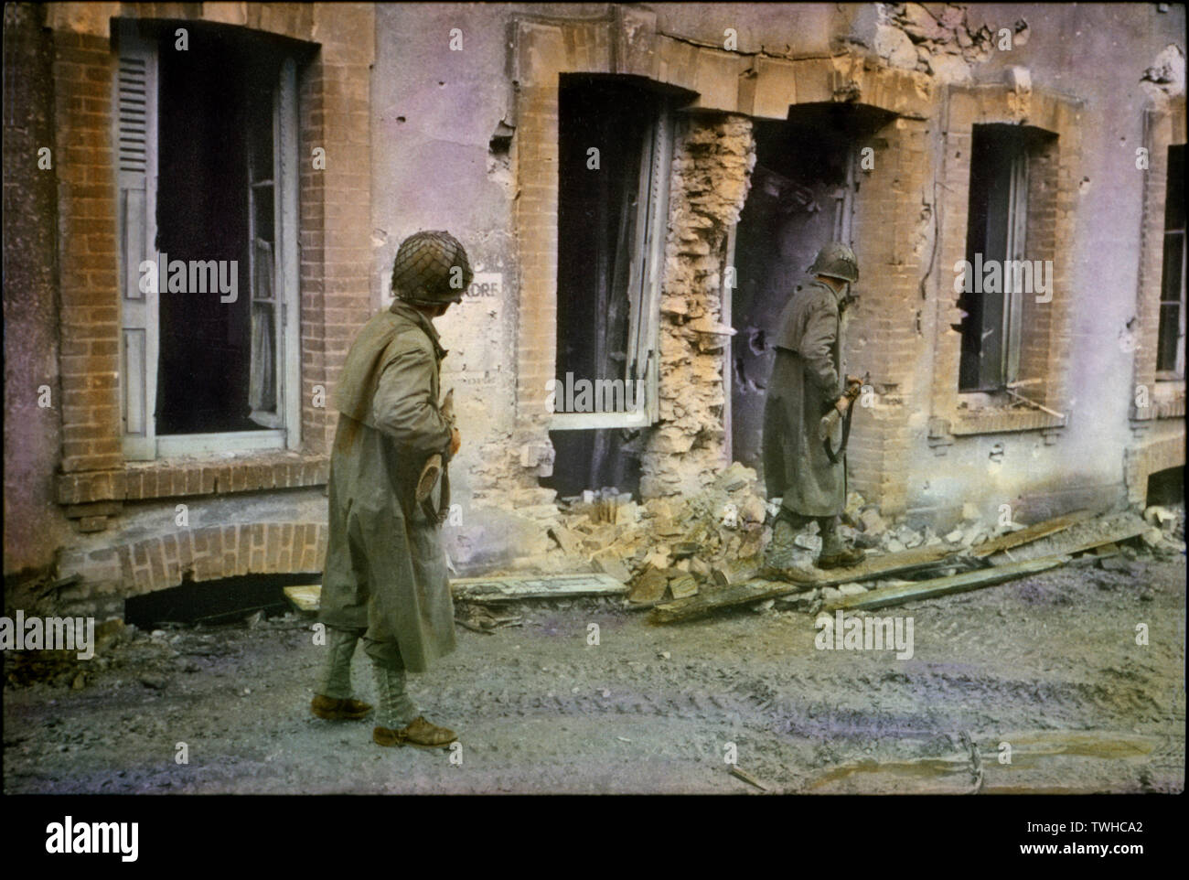 Deux soldats américains cherchant à travers les bâtiments endommagés, bataille de Normandie, Cherbourg, France, juin 1944 Banque D'Images