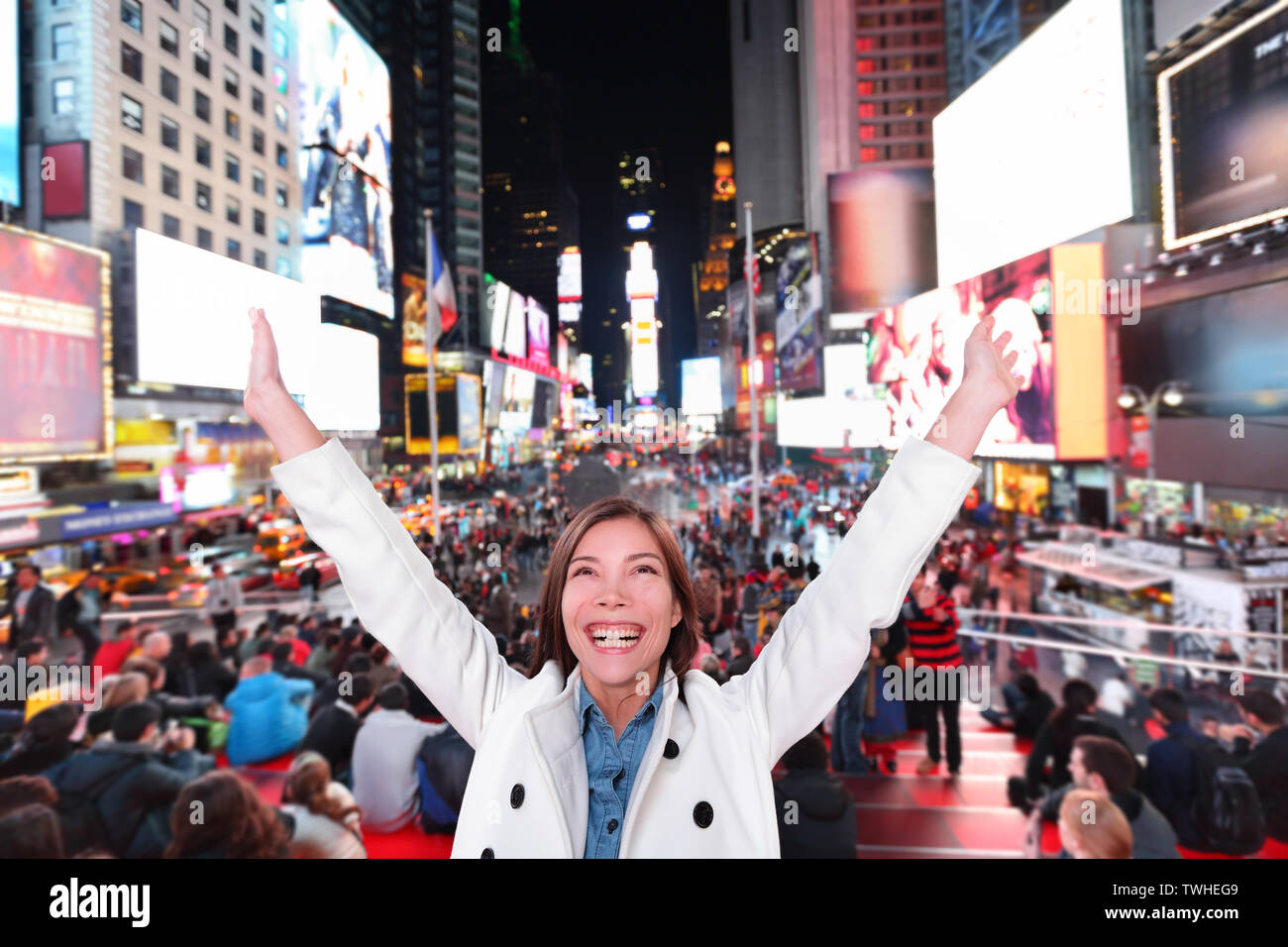 Heureux heureux femme dans la ville de New York, Manhattan, Times Square acclamations joyeuses fête de nuit avec bras levés. Smiling smiling Caucasian asiatiques multiethniques jeunes professionnels urbains dans la vingtaine. Banque D'Images