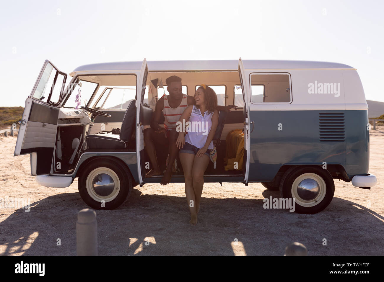 Heureux couple having fun in camper van at beach Banque D'Images