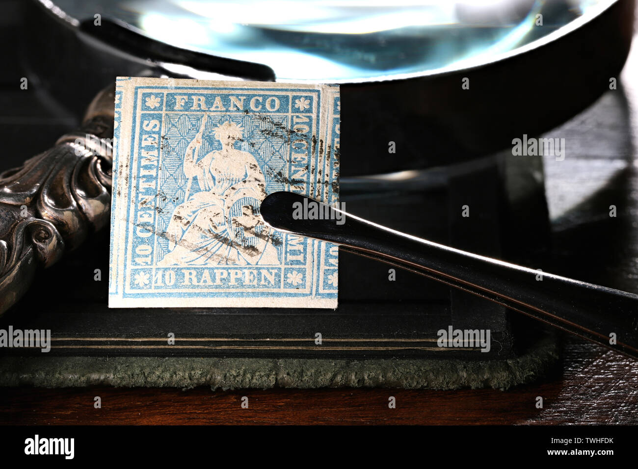 10 centimes suisses Strubel stamp détenues par des pincettes. Banque D'Images
