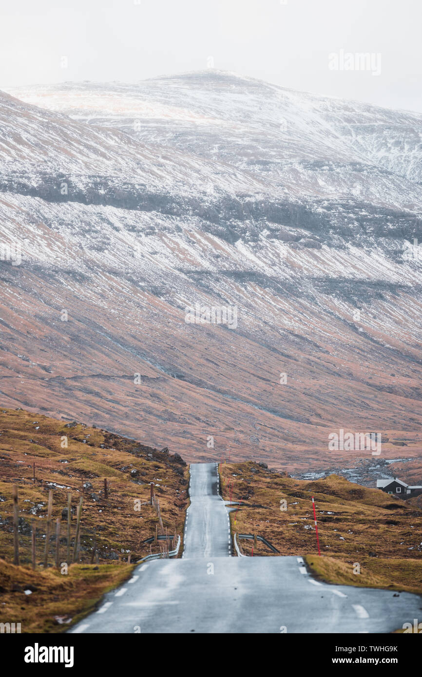 Vues road trip sur les routes sans fin sur les îles Féroé avec des pics de montagne couverte de neige, ciel bleu et nuages bas au printemps (îles Féroé) Banque D'Images