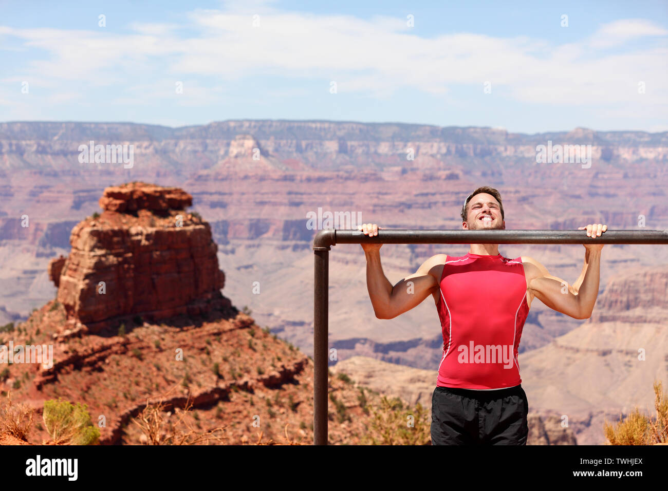 Athlète Fitness formation homme tirer ups dans nature extraordinaire paysage du Grand Canyon. La formation de force de travail mâle sur l'exercice de l'extérieur en été faire tirer-se lève et chin-ups. Banque D'Images
