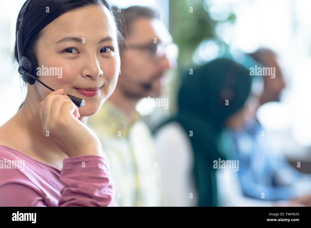 Female customer service executives talking on headset at desk Banque D'Images