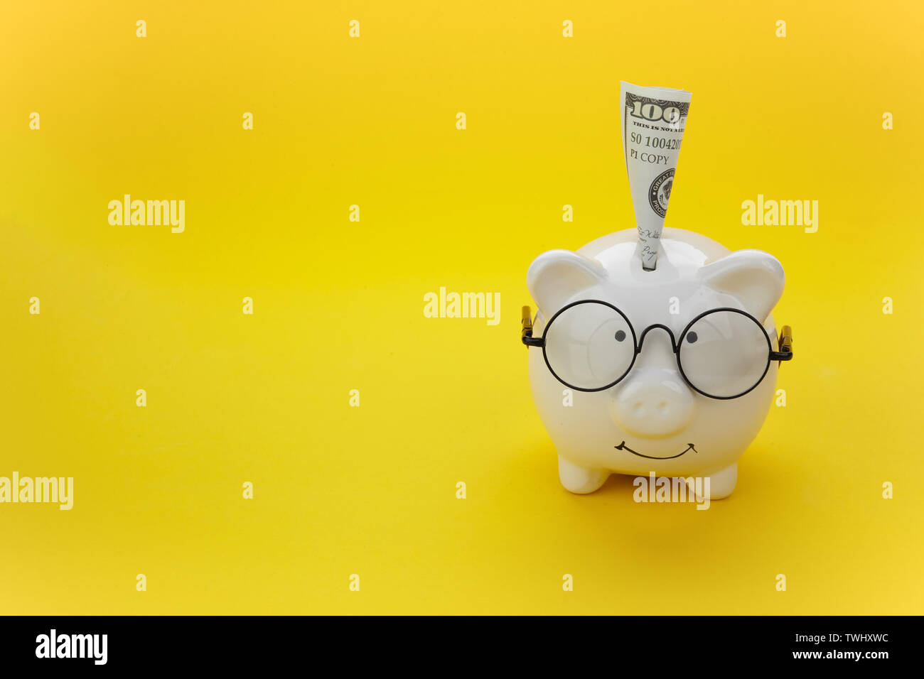 White piggy bank wearing a lunettes noires sur fond jaune Banque D'Images