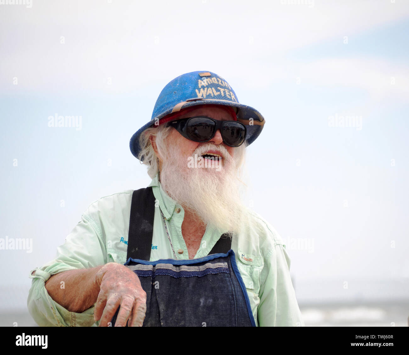 Barbe blanche Amazin', 'Walter' McDonald dans un pith helmet prend une pause à partir de la sculpture à la Texas 2019 Sandfest à Port Aransas, Texas USA. Banque D'Images