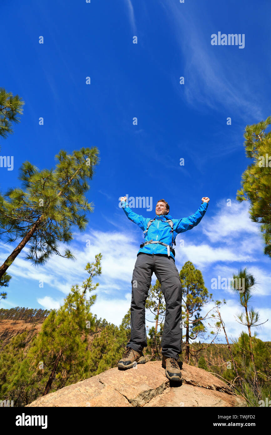 Homme randonnée sommet atteindre top cheering célébrant en montagne avec les bras tendus vers le ciel. Happy male hiker. Banque D'Images